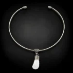Collar rígido de alpaca con colmillo natural de ciervo sobre fondo negro