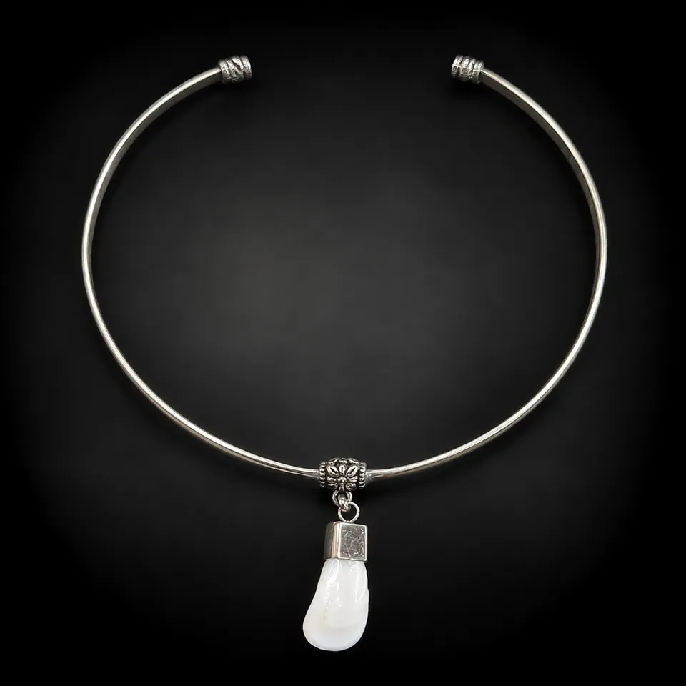 Collar rígido de alpaca con colmillo natural de ciervo sobre fondo negro