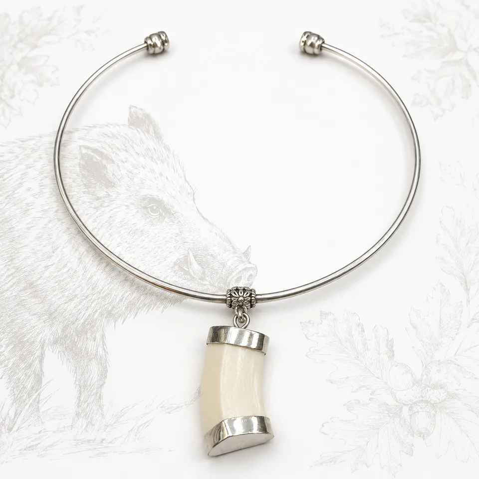 Pulsera rígida de alpaca con colmillo natural de jabalí sobre fondo claro