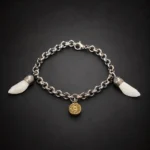 Pulsera de acero con dientes naturales de jabalí y colgante de bala sobre fondo negro difuminado