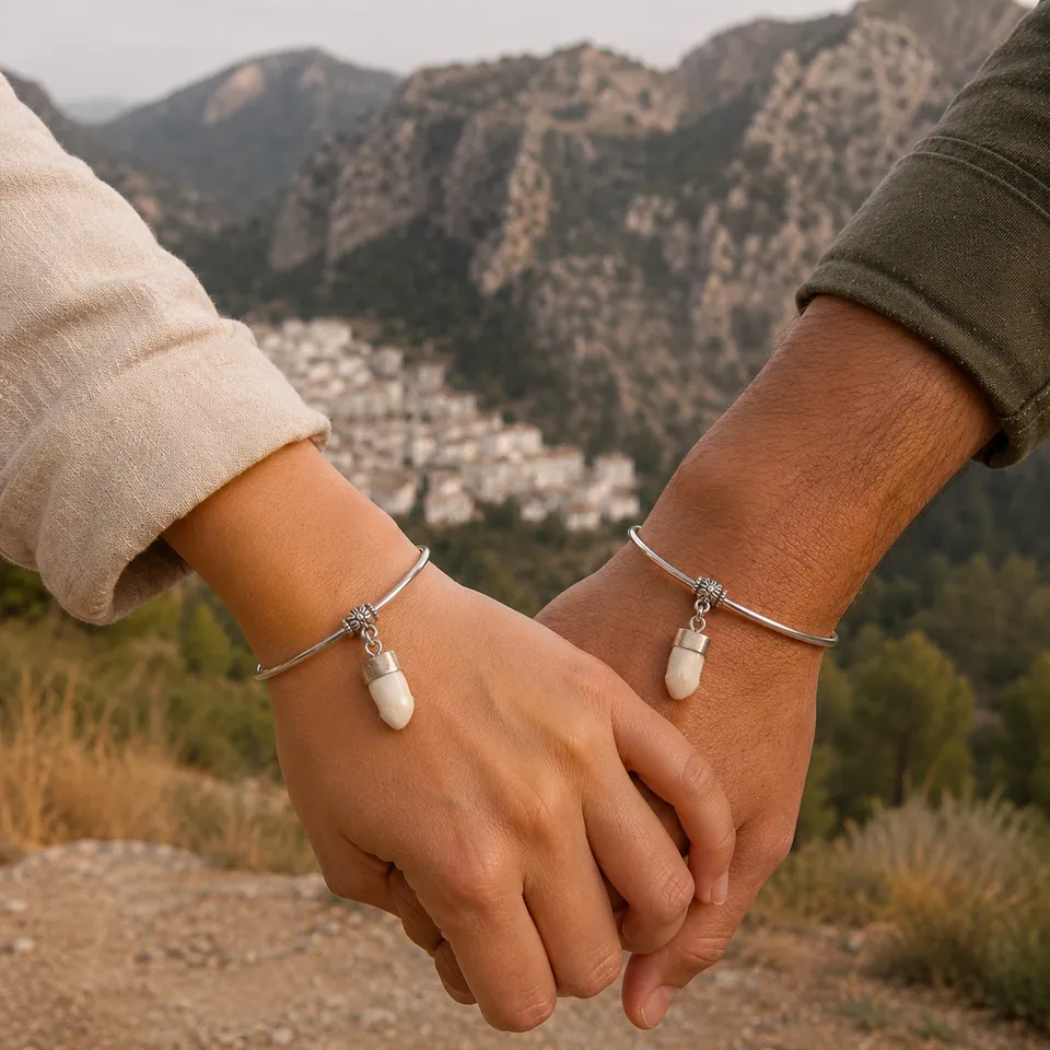 Dos personas cogidas de la mano con pulseras rígidas de alpaca y colmillo natural de ciervo en la Sierra de Cazorla