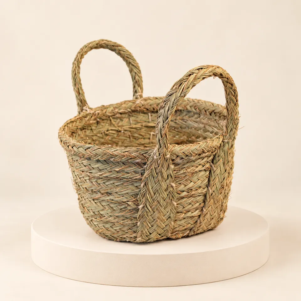 Cesta bolso artesanal de esparto con dos asas sobre plataforma y fondo claro